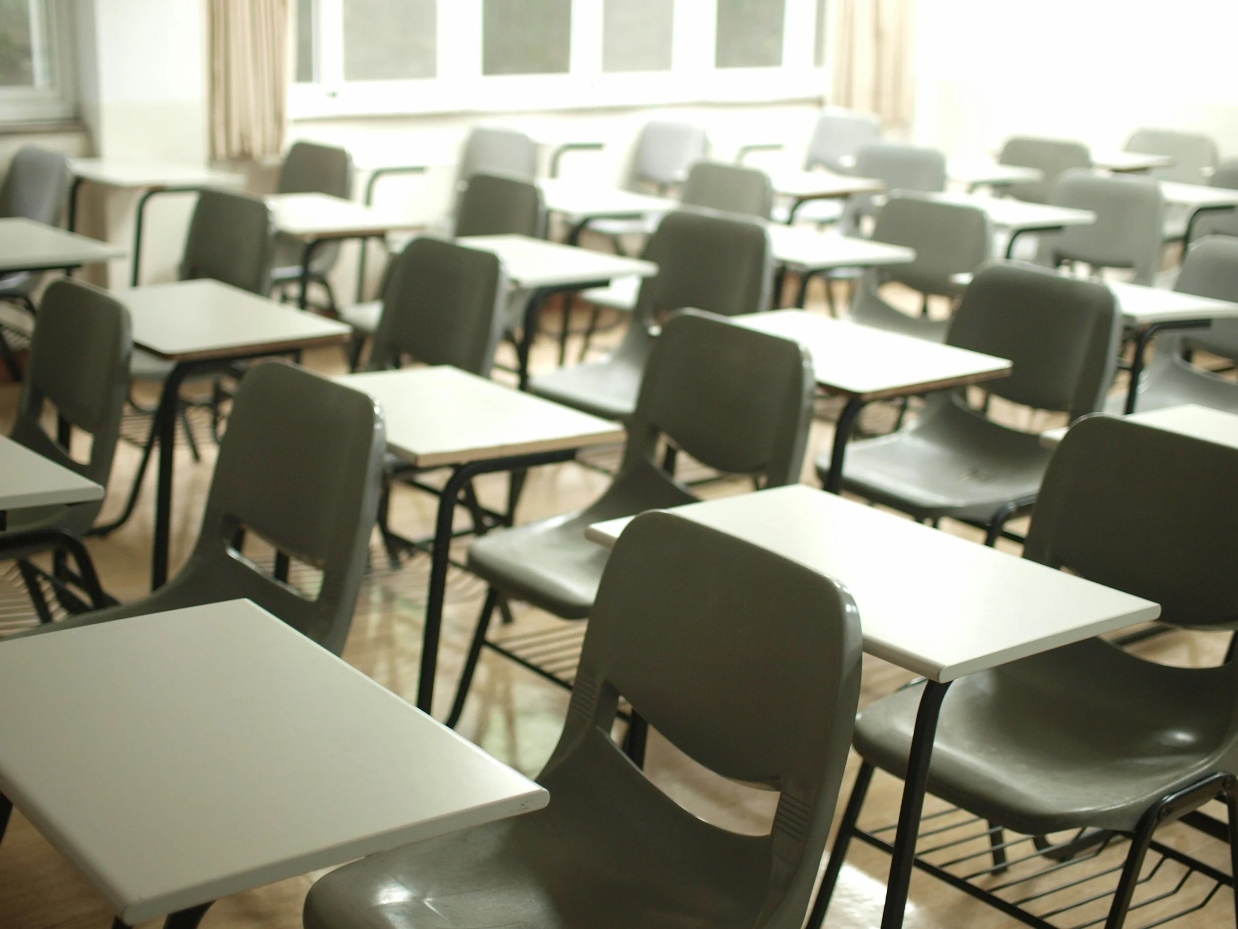Empty classroom with desks and natural light, representing high school juniors and seniors preparing for academic and life transitions.