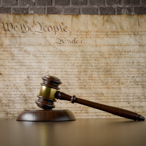 Gavel resting on a table in front of the U.S. Constitution document.