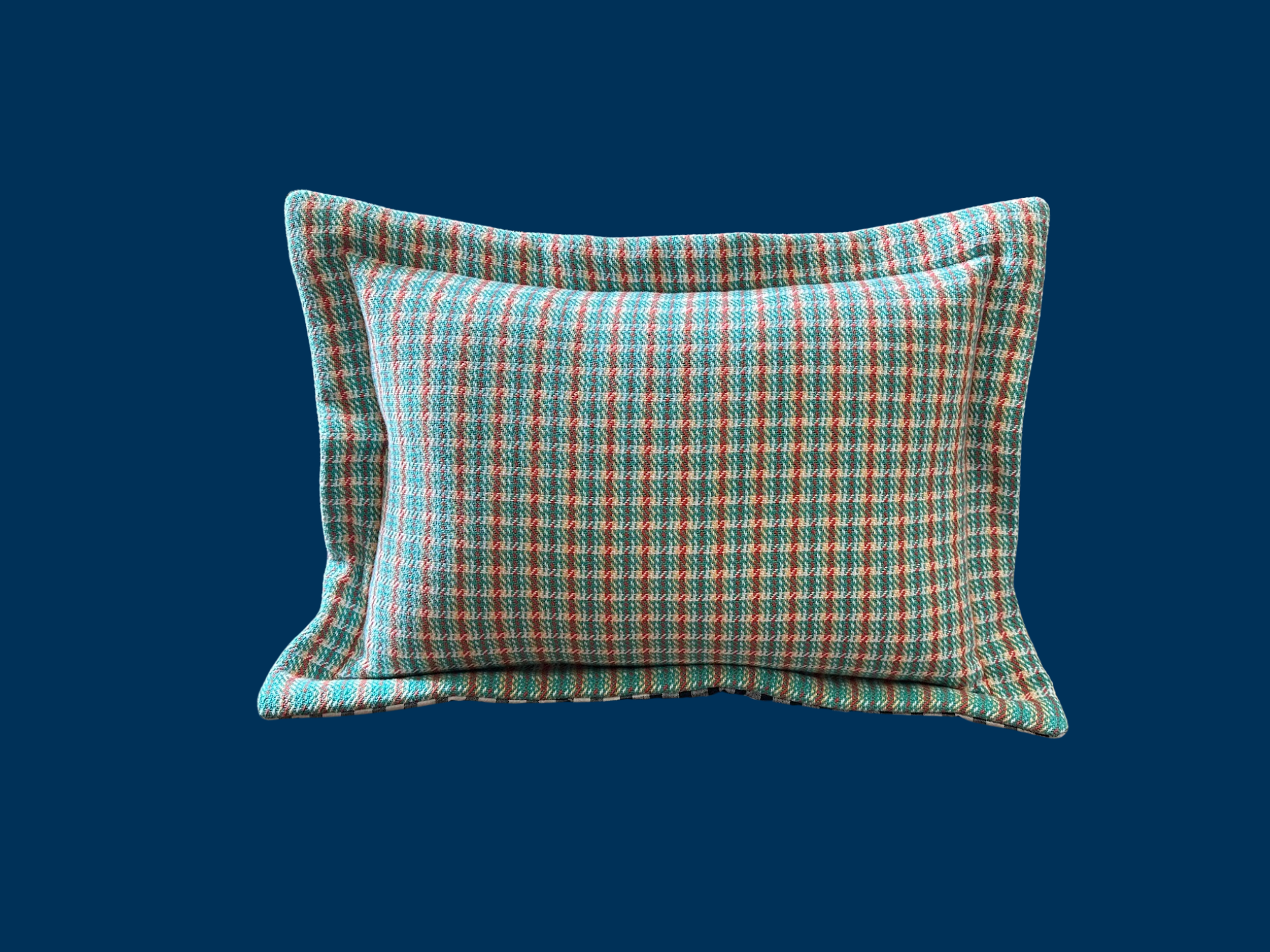 Two plaid pillows, one partially behind the other, on a solid dark teal background.