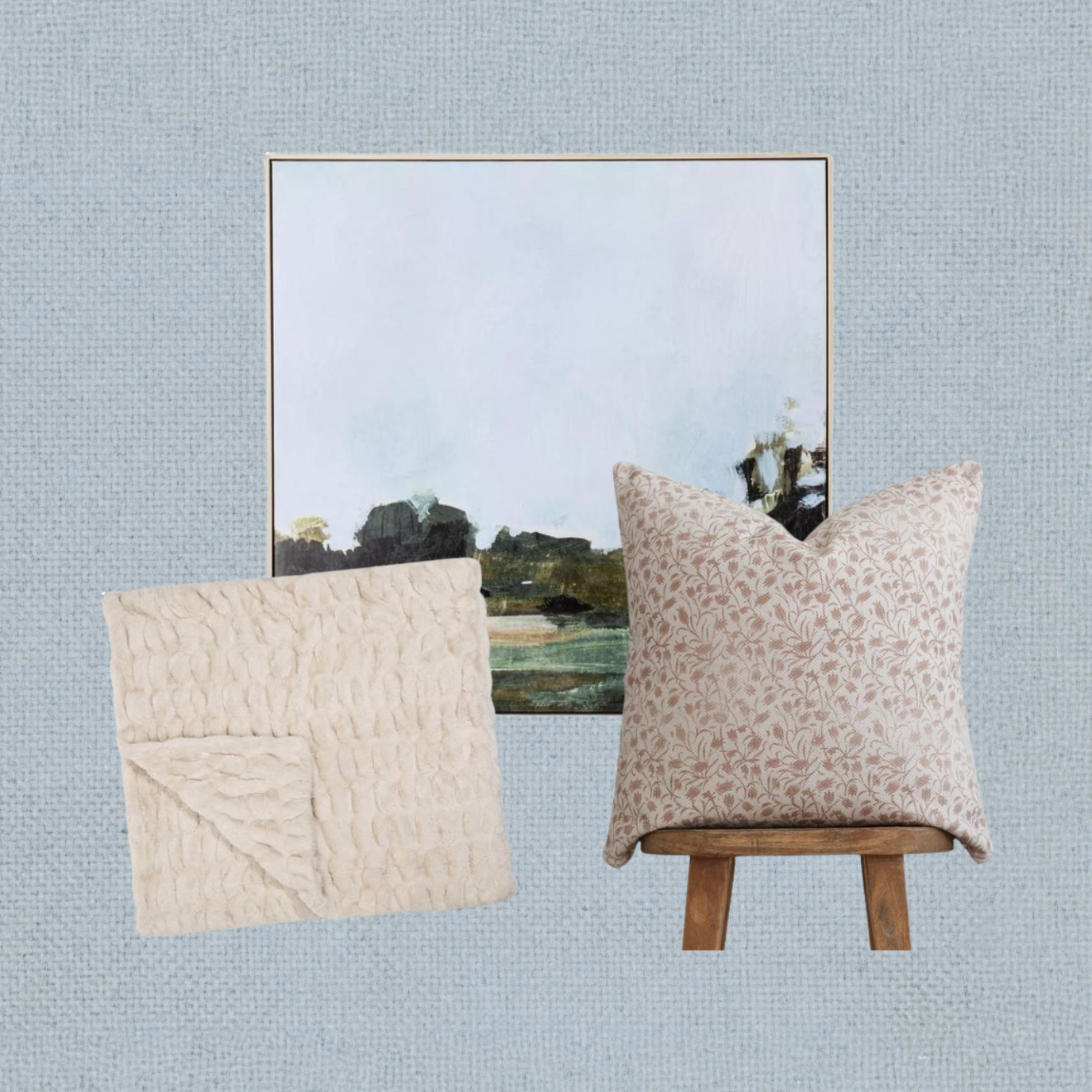 Aesthetic home decor setup with two pillows and a landscape painting against a textured blue wall.