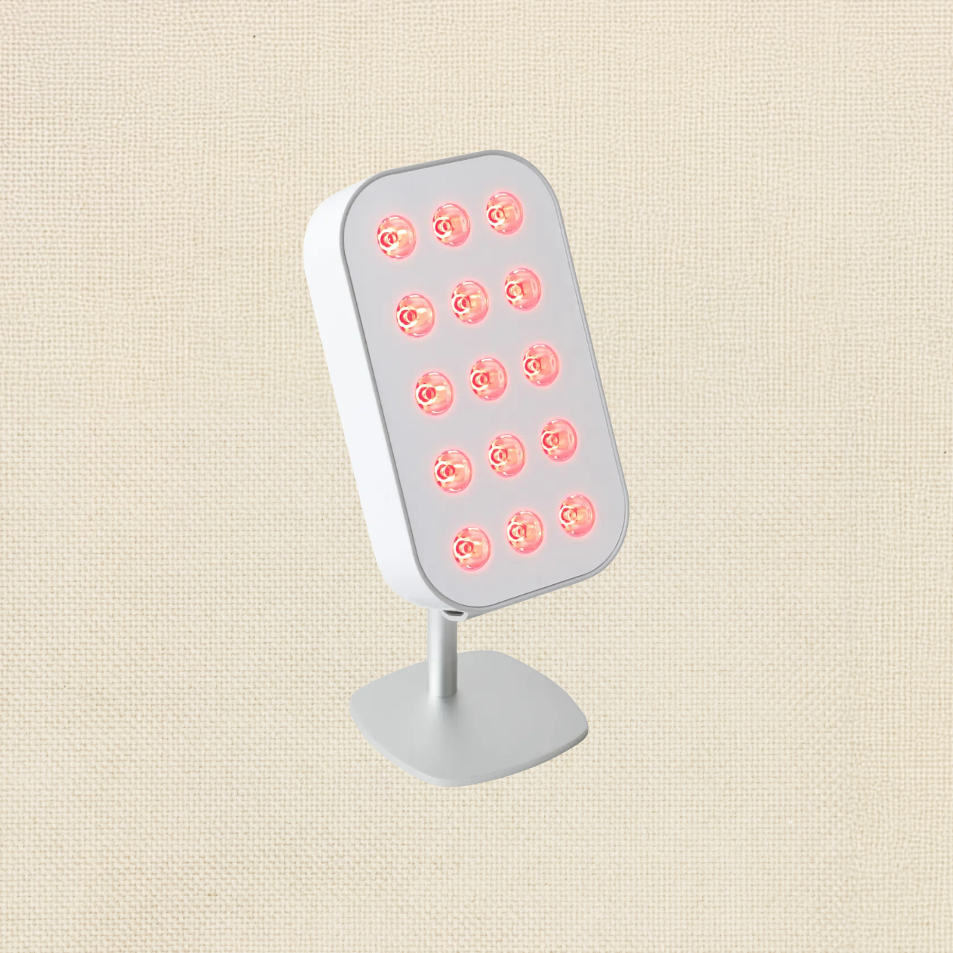 A white LED therapy light with multiple red bulbs on a beige background.
