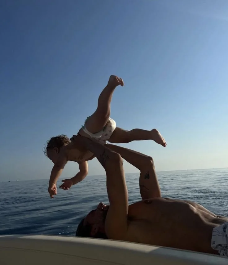 Father lifting baby in the air at the beach representing the success of male fertility journey with Supersperm Plus