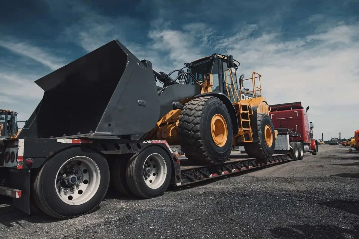 Large yellow bulldozer loaded on a flatbed truck - Work with Fox Logistics—trusted freight solutions for shippers and carriers with flatbed, oversize, and project expertise.