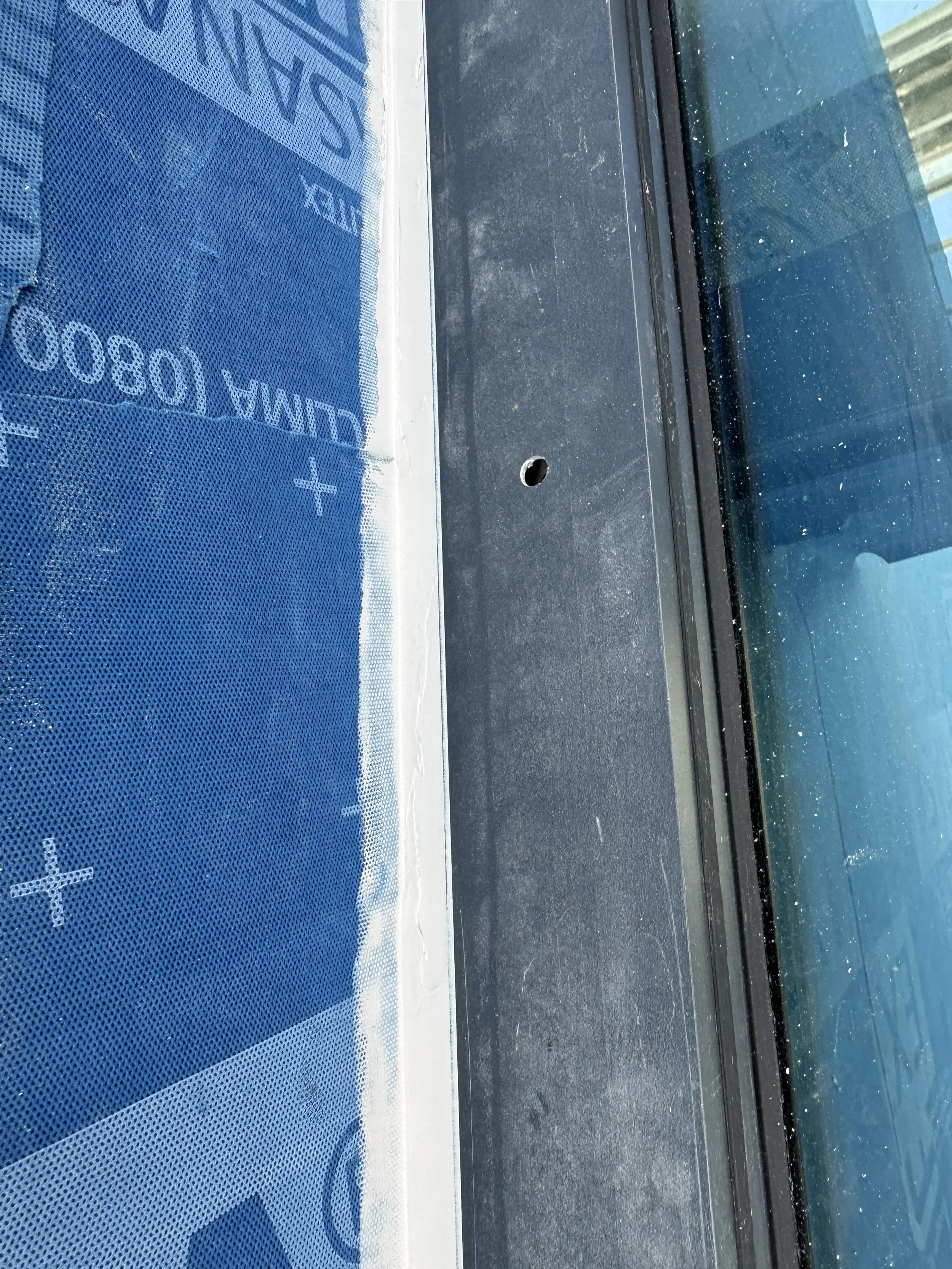 Close-up photo of a car dashboard with a blue sunshade that has white text and logo, showing part of the windshield and dashboard.