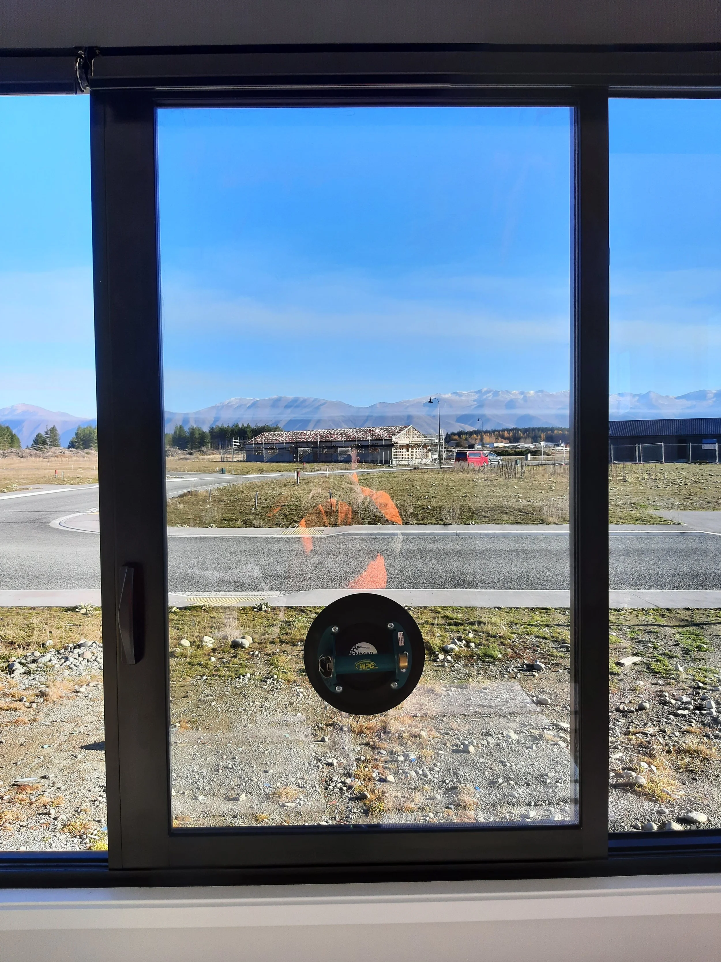 View through new glazing and joinery works with a glass window showing a rural scene with reflected in the glass.