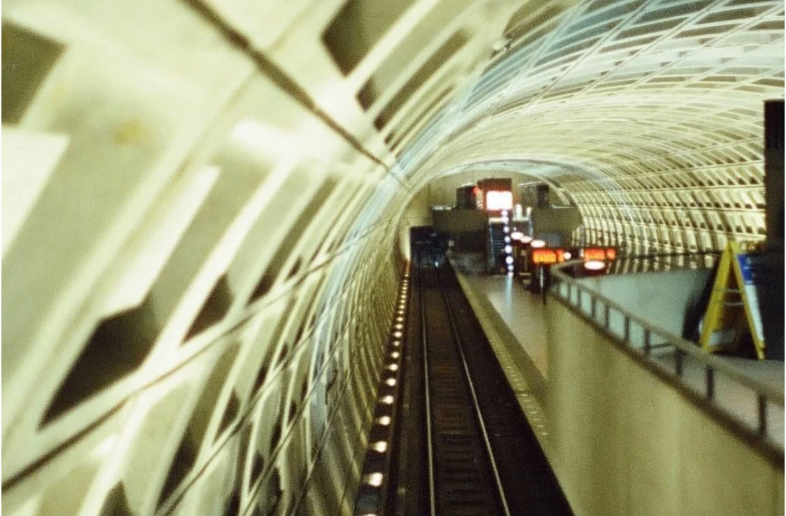 View of an underground subway tunnel with railway tracks and station platform