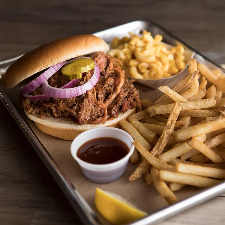 BBQ sandwich with smoked meat and fries.