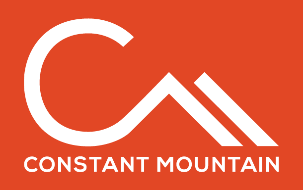 Logo with a stylized white mountain peak and the text "CONSTANT MOUNTAIN" below on an orange background.