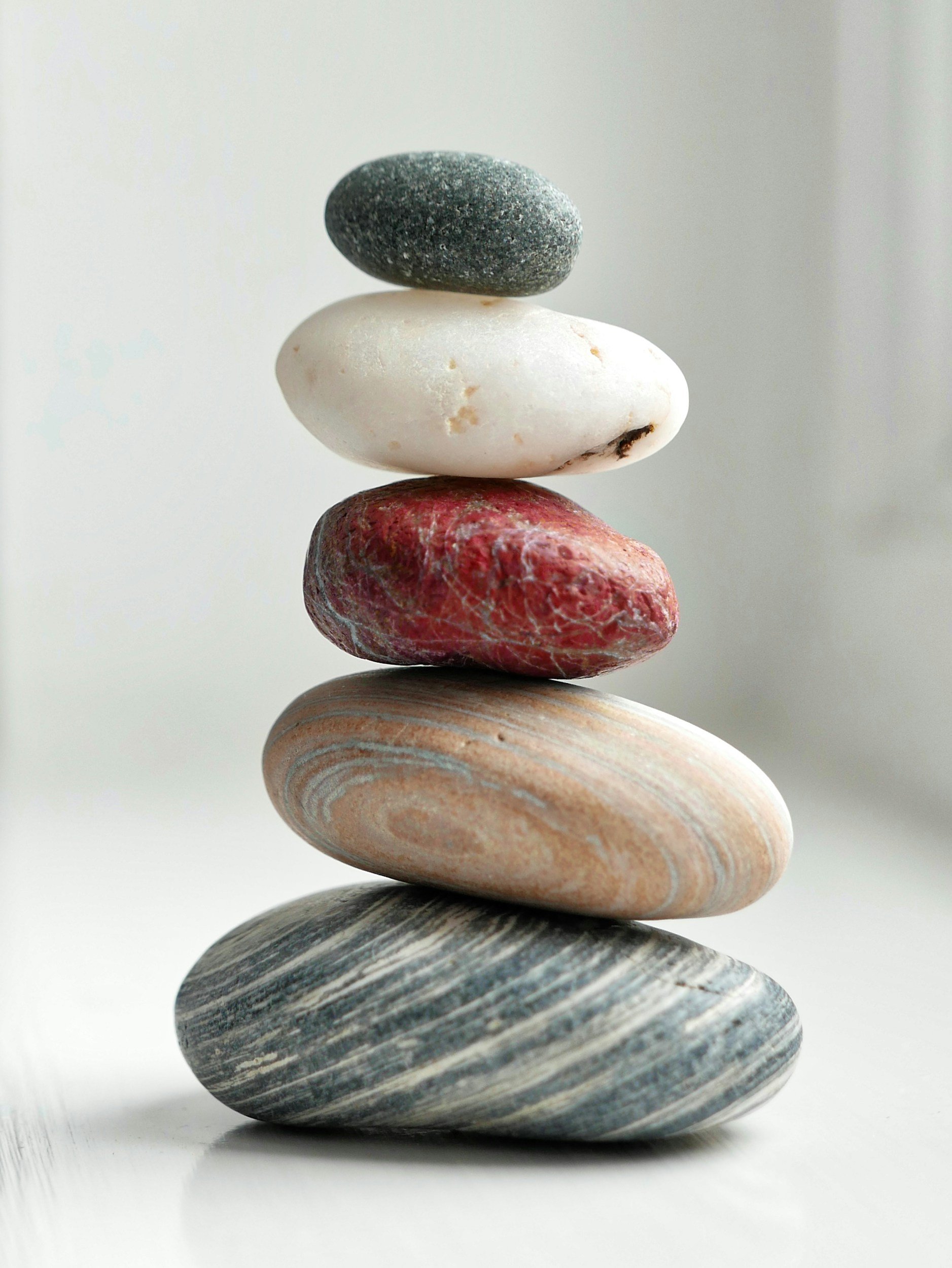 Stacked smooth stones of various colors and textures, arranged in a balanced tower.
