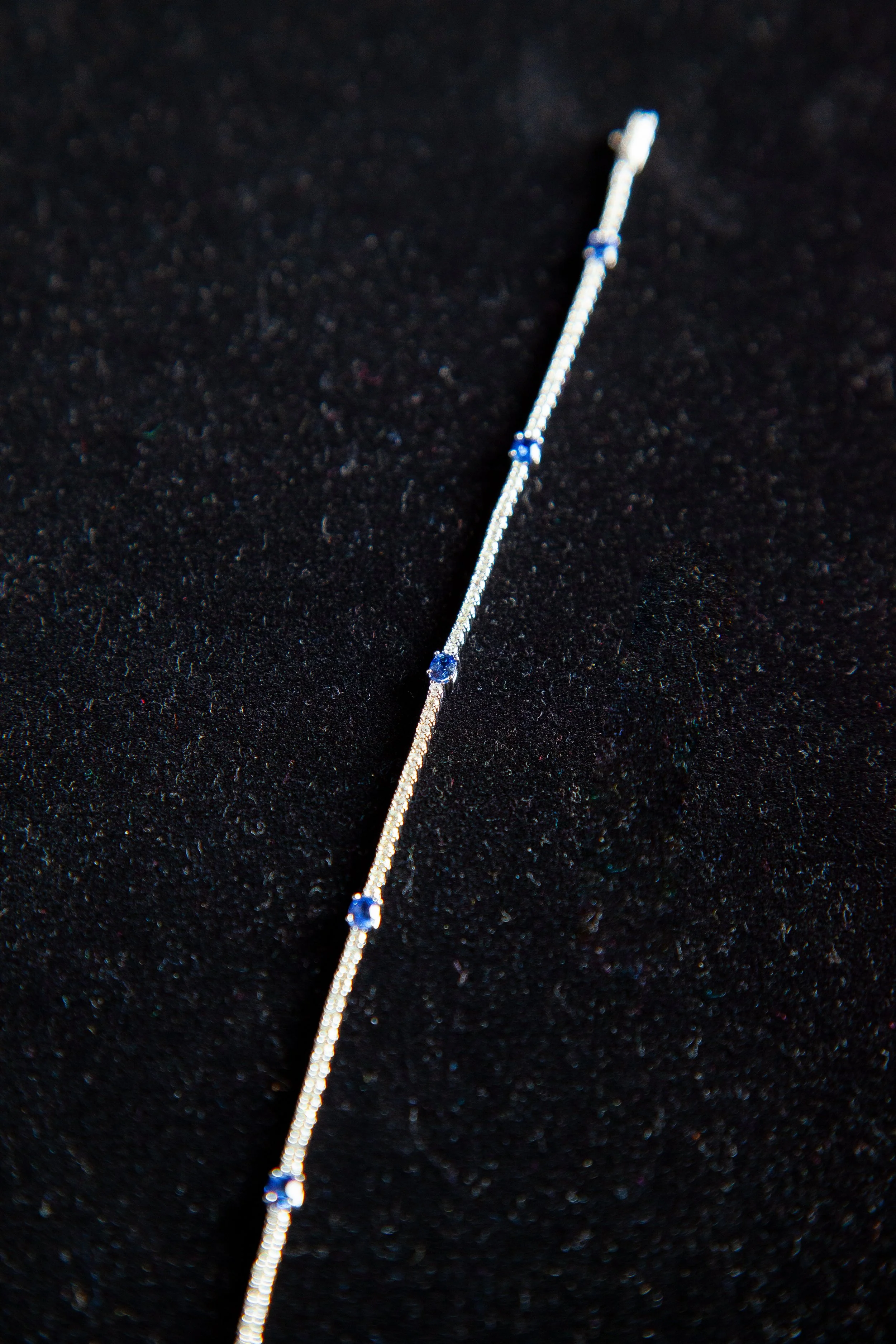 AN 18K WHITE GOLD LINE BRACELET SET WITH 5 OVAL SAPPHIRES, EACH 0.25 CARATS, ALONG WITH 80 ROUND BRILLIANT CUT DIAMONDS. SEE THE CURRENT REPLACEMENT APPRAISAL FOR
DETAILS. CURRENTLY APPRAISED AT $5,900.00 