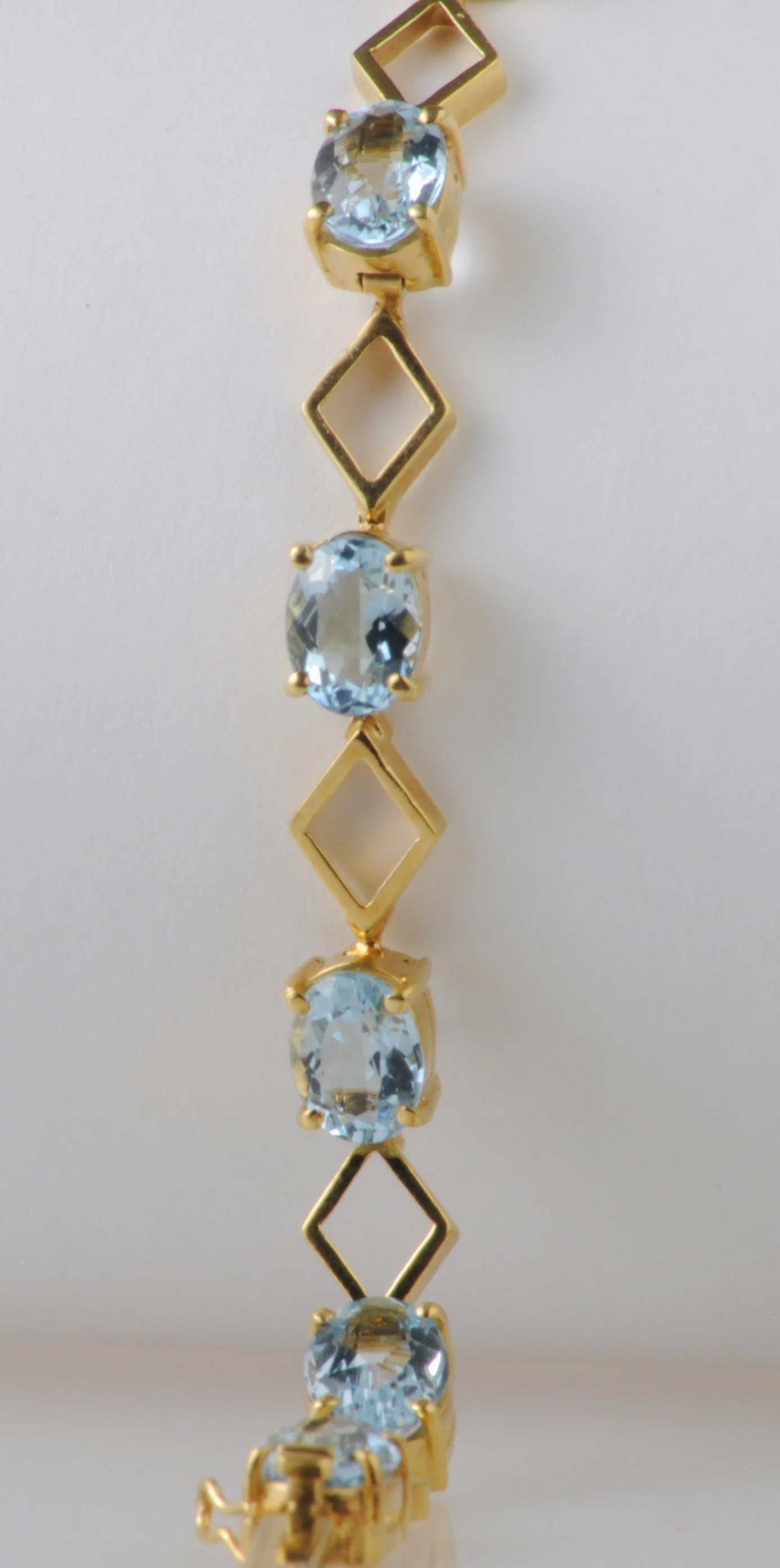 18K aquamarine line bracelet with 10 oval aquamarines. 9.52 grams of 18k yellow gold.