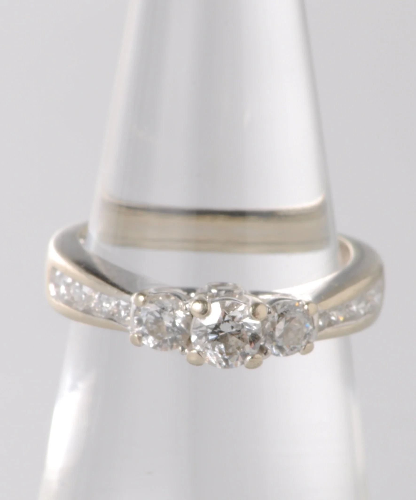 14k white gold 3 stone Diamond engagement ring with one round brilliant cut .30ct and two round brilliant cut .15ct diamonds. Gold weight 2.5 grams