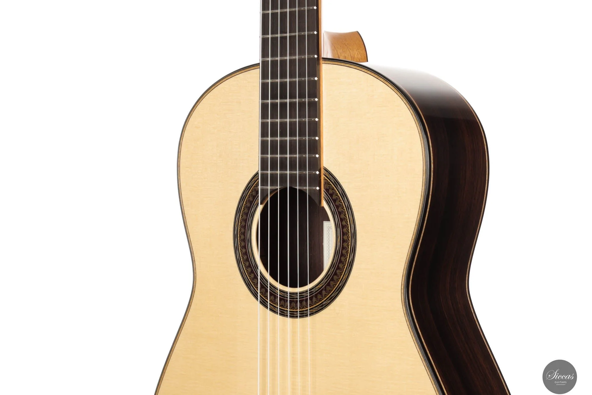 Close-up of an acoustic guitar with a light-colored top and dark sides, showing the sound hole, strings, and part of the neck against a white background.
