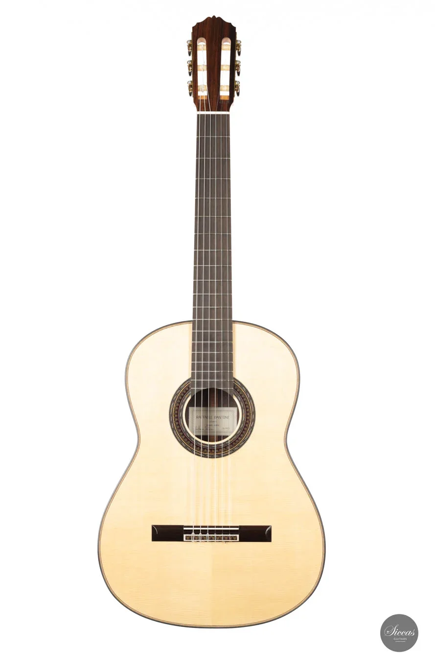 An acoustic guitar with a light-colored wooden body, dark fretboard, and tuning pegs.