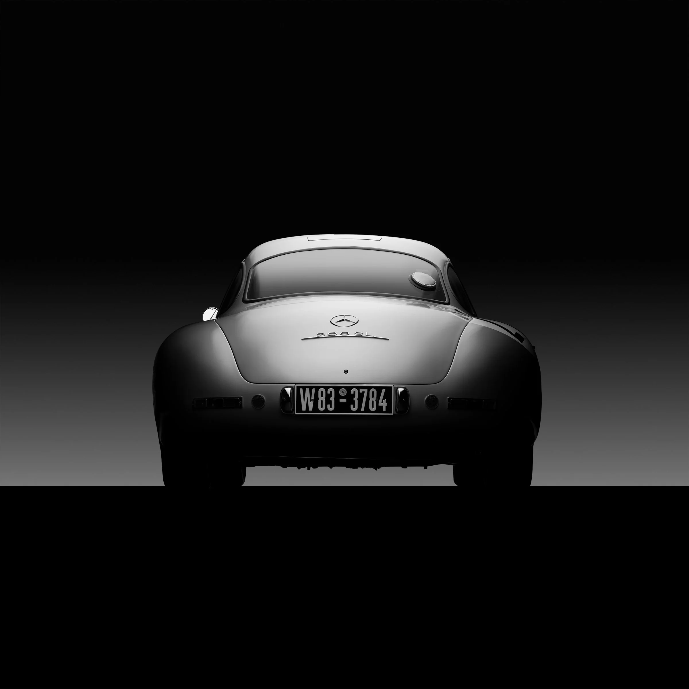 Silver Silence by Bill Pack — a reductive automotive portrait shaped through hand-controlled illumination, revealing underlying structure, shadow, and form.
