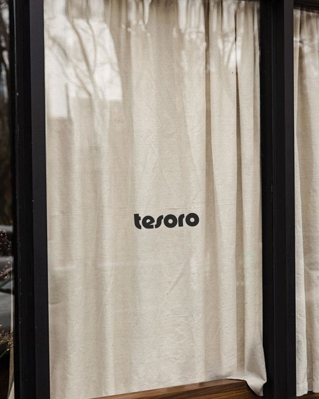 Curtain with the word 'tesoro' printed on it in black letters.