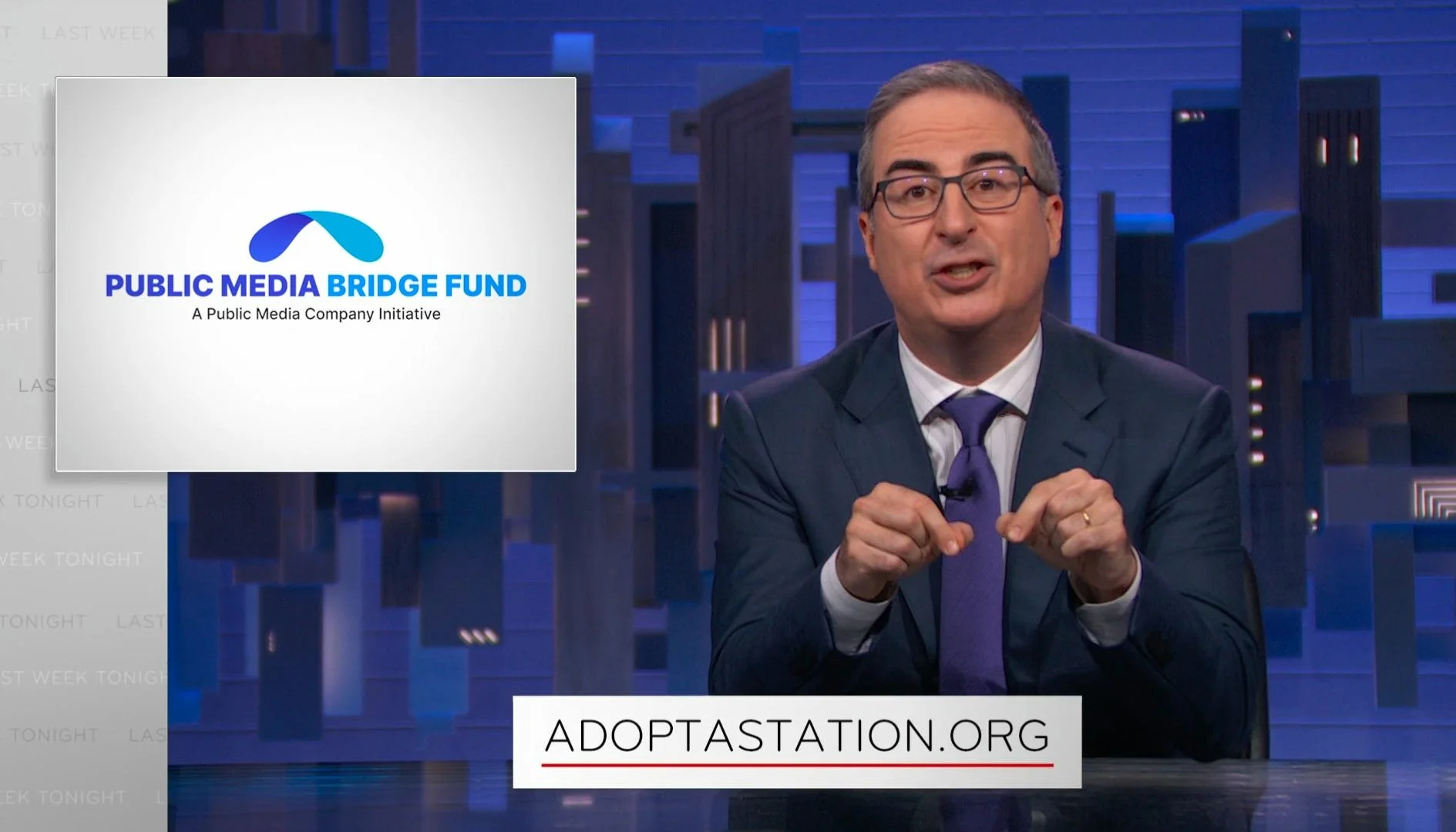 A man in a suit speaking at a table with a banner behind him displaying the website ADOPTATION.ORG. A graphic on the left promotes the PUBLIC MEDIA BRIDGE FUND, an initiative by a Public Media Company.