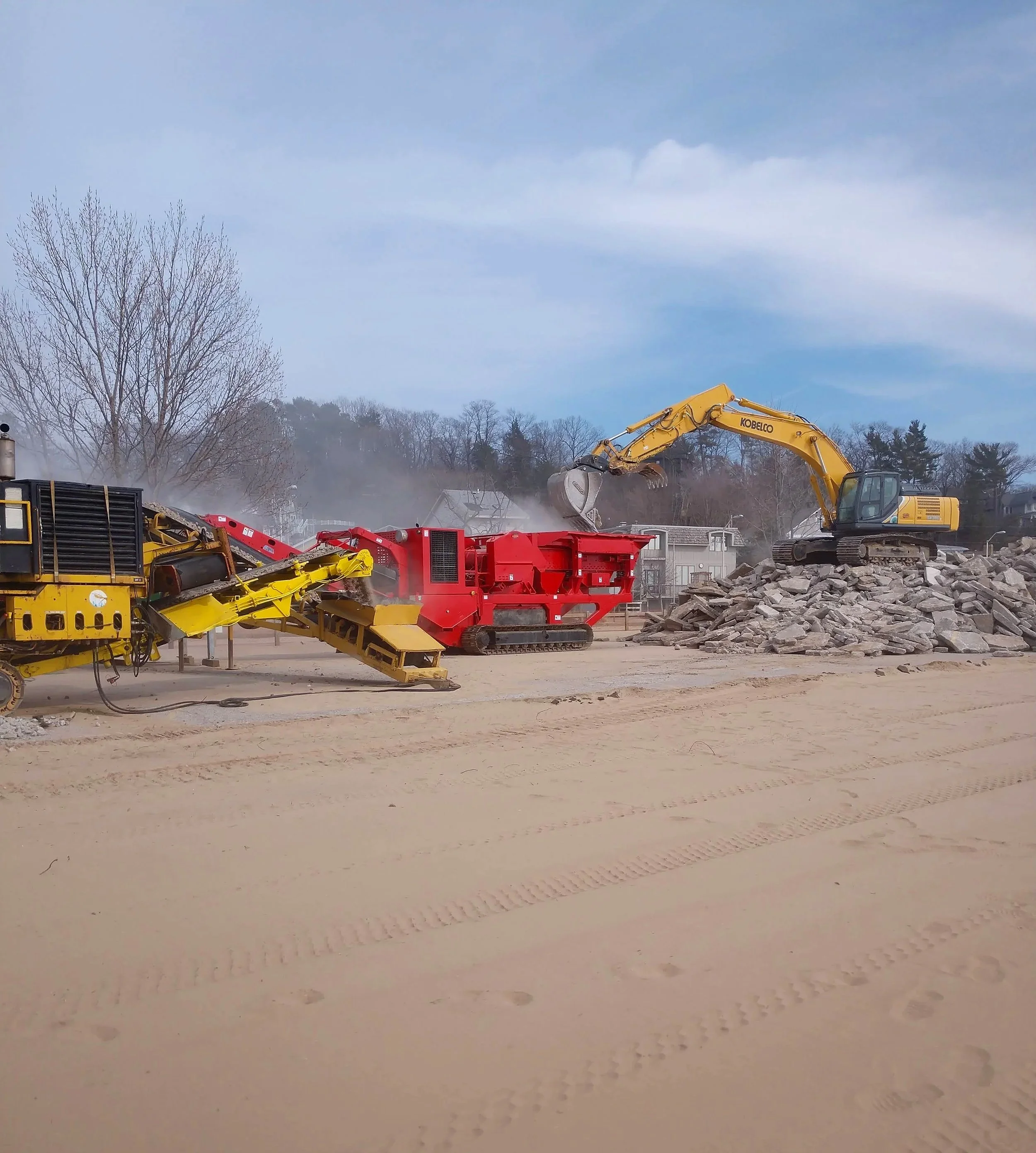 Mobile crushing and screening equipment processing recycled concrete on-site.