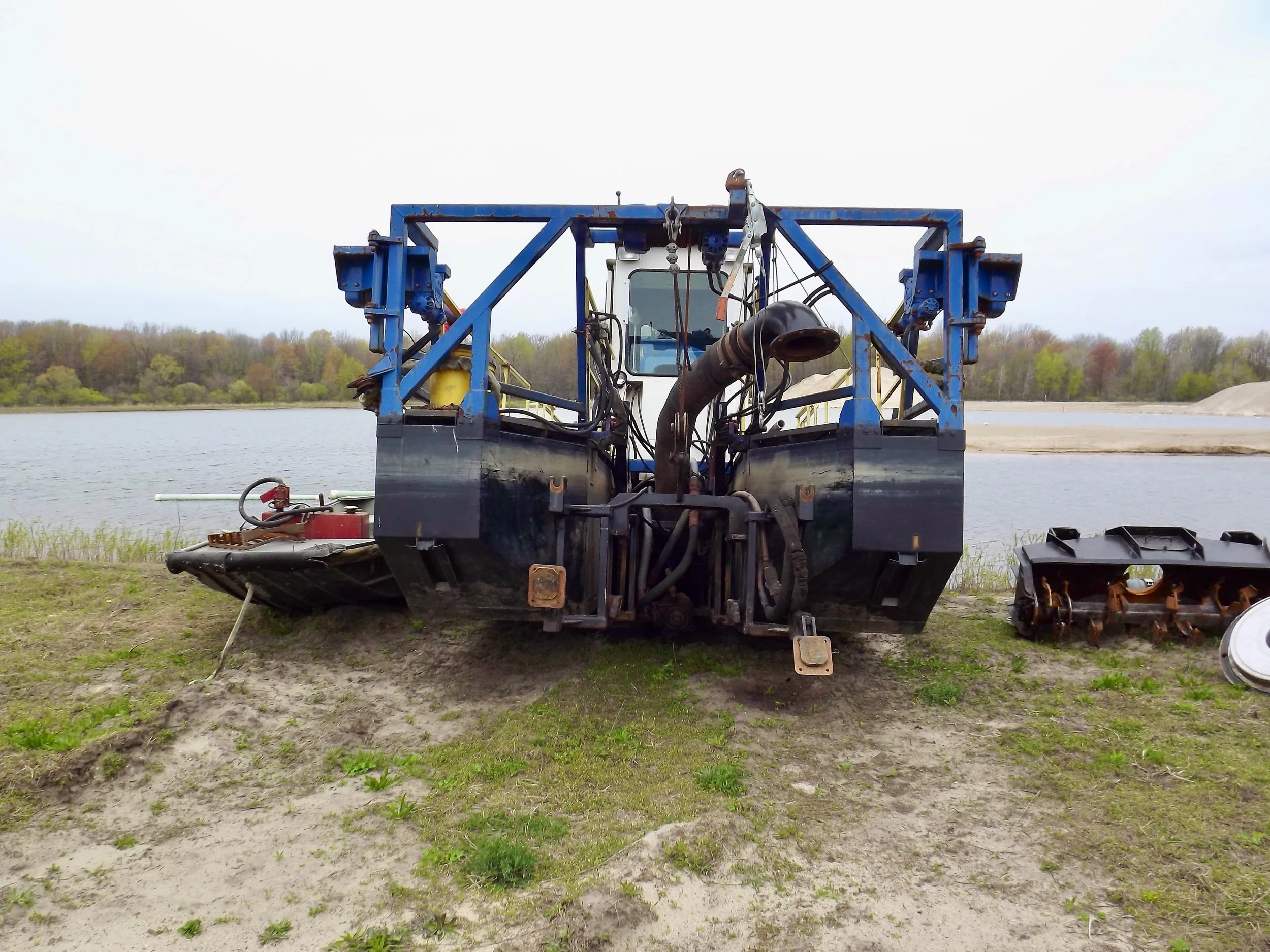 Dan Hoe Excavating dredging equipment staged on shoreline for sediment removal and marina maintenance.