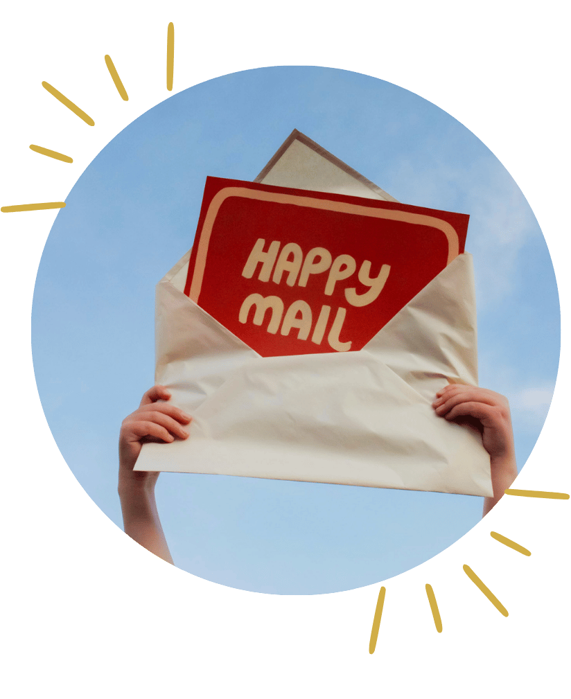 Child's hands holding an oversized envelope and letter reading "happy mail" against the sky