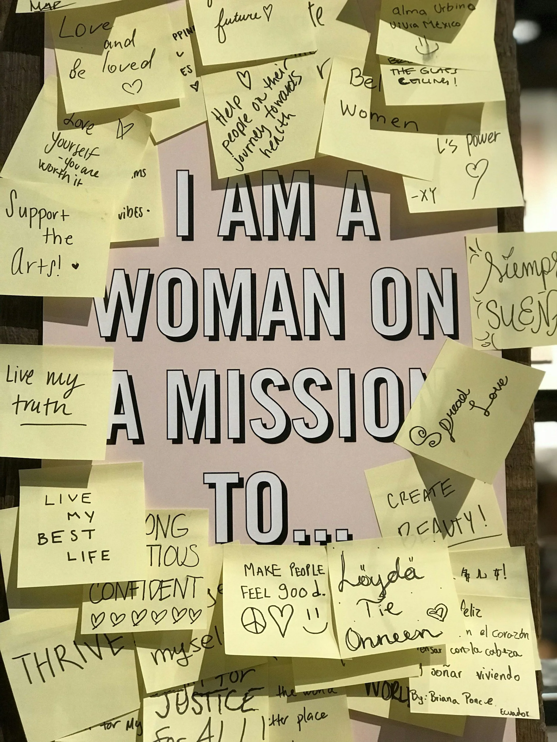 Posters with positive affirmations and motivational messages surrounded by sticky notes with handwritten quotes, words, and symbols expressing empowerment, love, confidence, and self-belief.