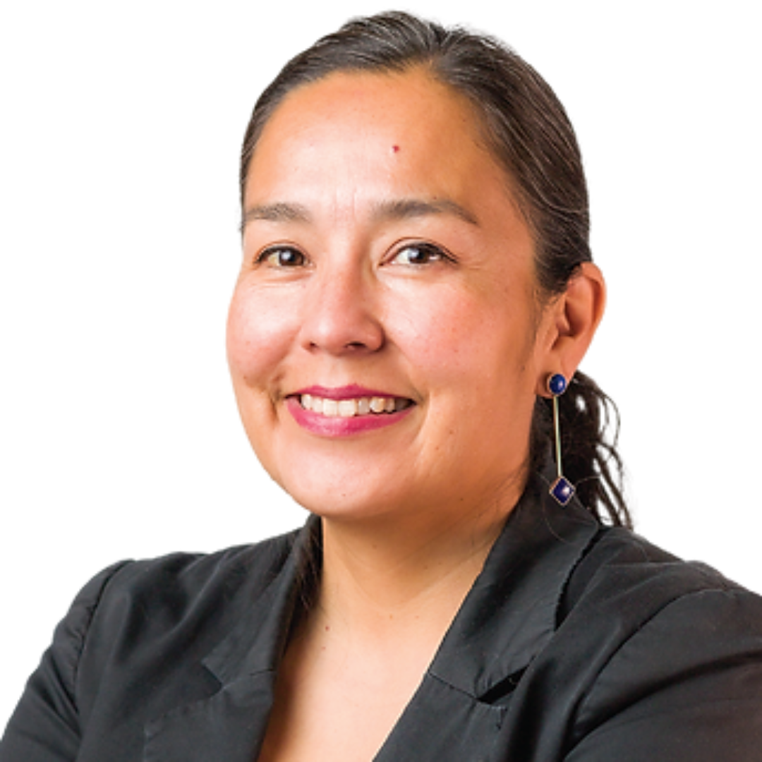 A smiling woman with dark hair pulled back, wearing a black blazer and blue earrings, looking at the camera.