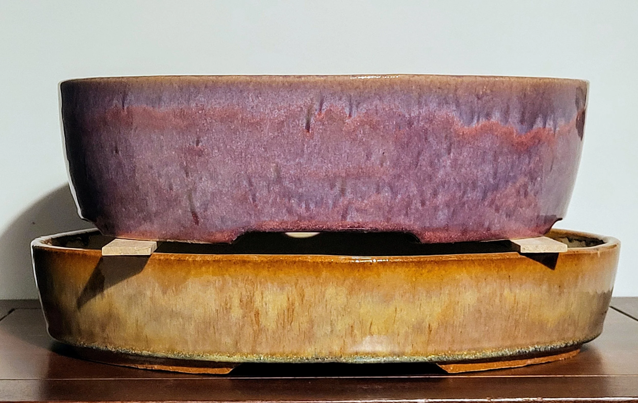 Two large ceramic bowls stacked on top of each other on a wooden surface.
