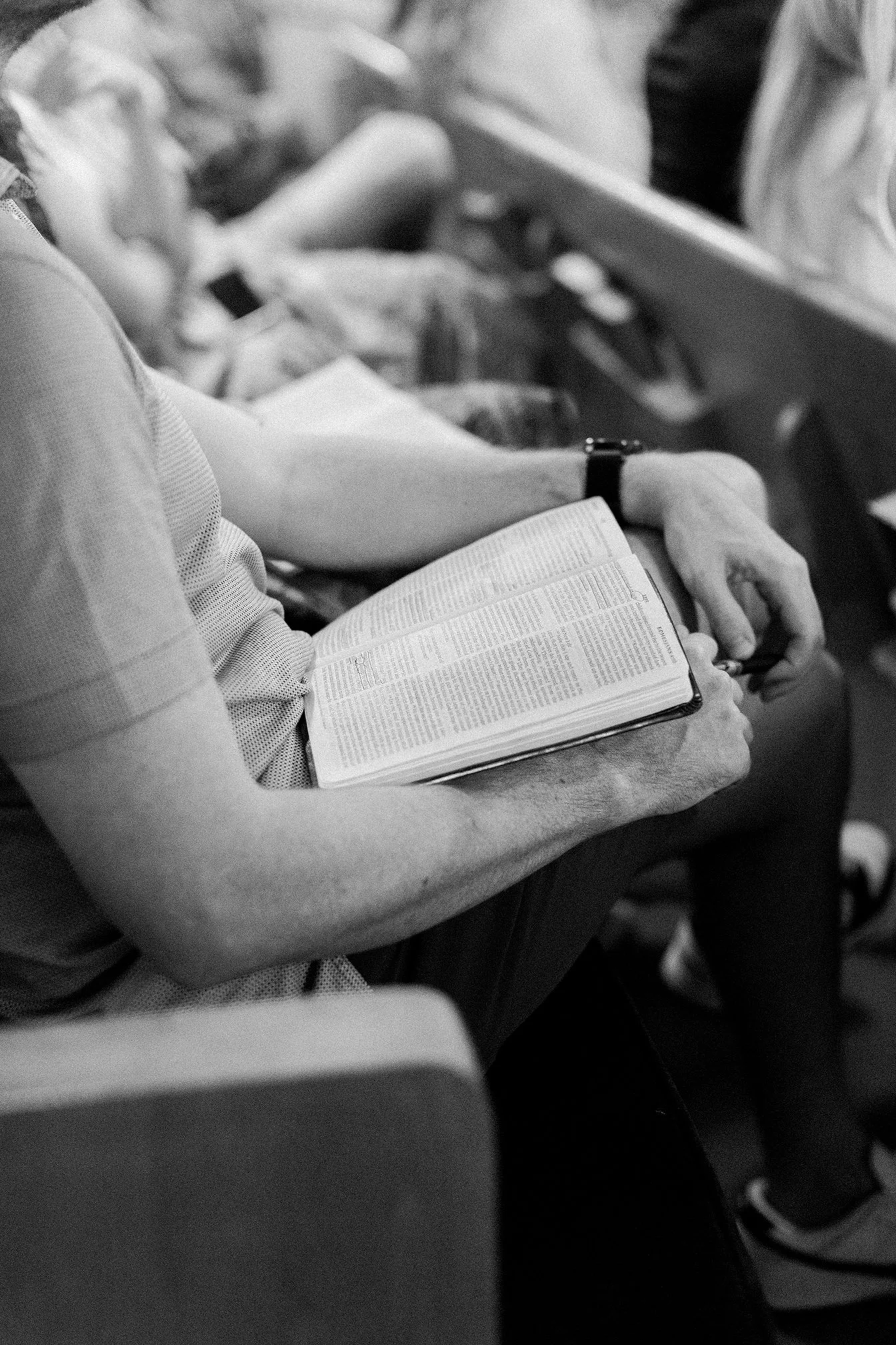 A person sitting in an airplane seat reading a book.