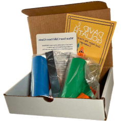 A box filled with various craft supplies, including glue sticks, a paintbrush, and instruction booklets.