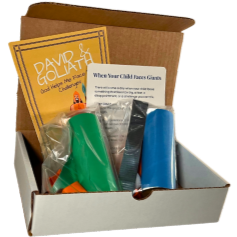 Open box containing multiple colorful party blowers, a yellow card, and some paper notes.