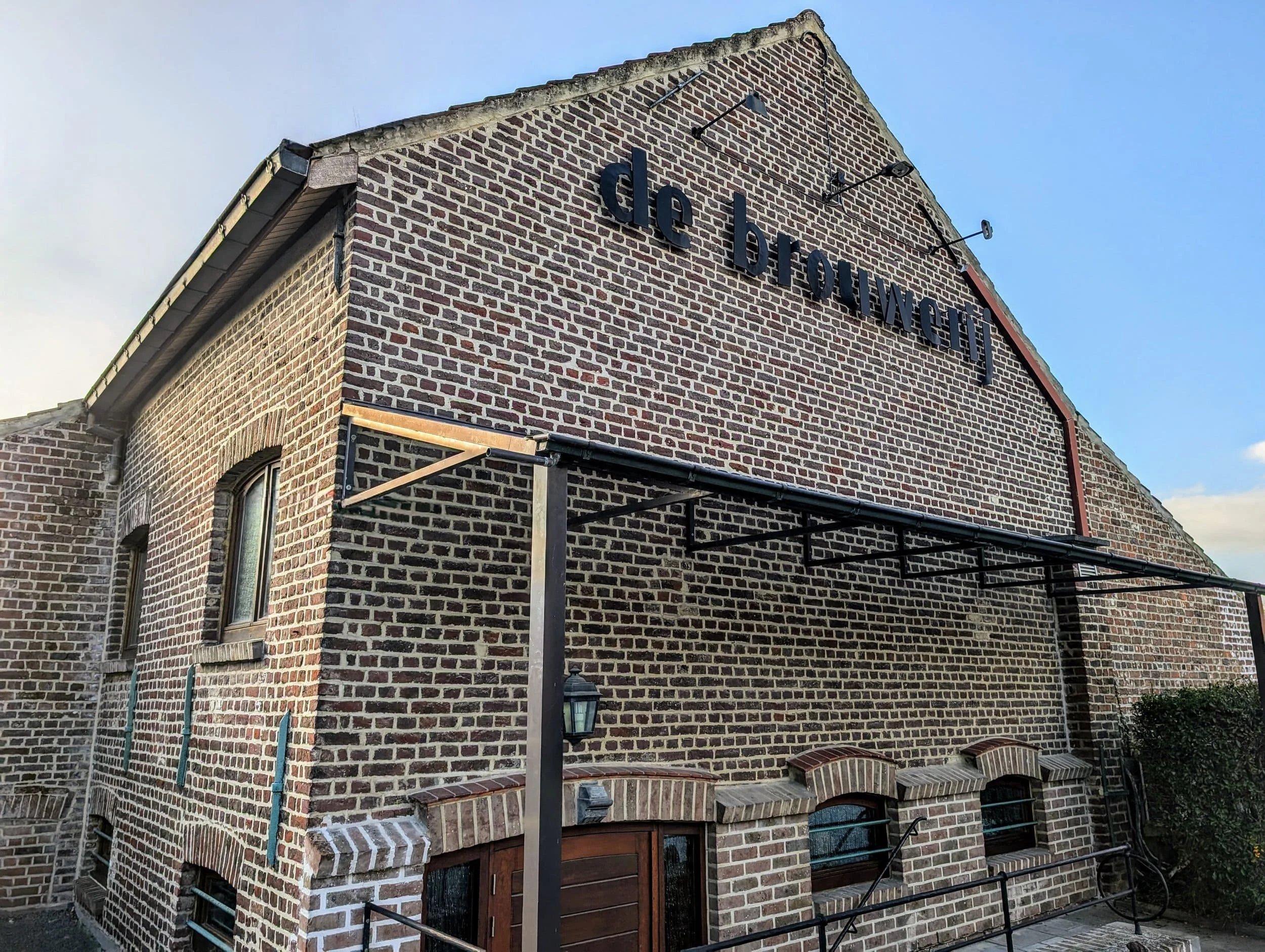 Een oude bakstenen gebouw met de tekst 'de brouwerij' aan de muur.
