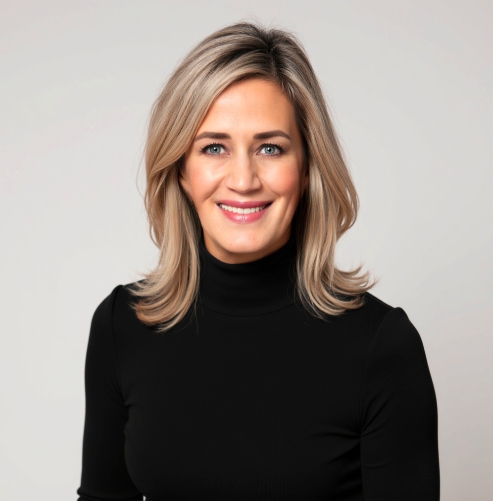 A smiling woman with shoulder-length blonde hair wearing a black turtleneck against a light gray background.