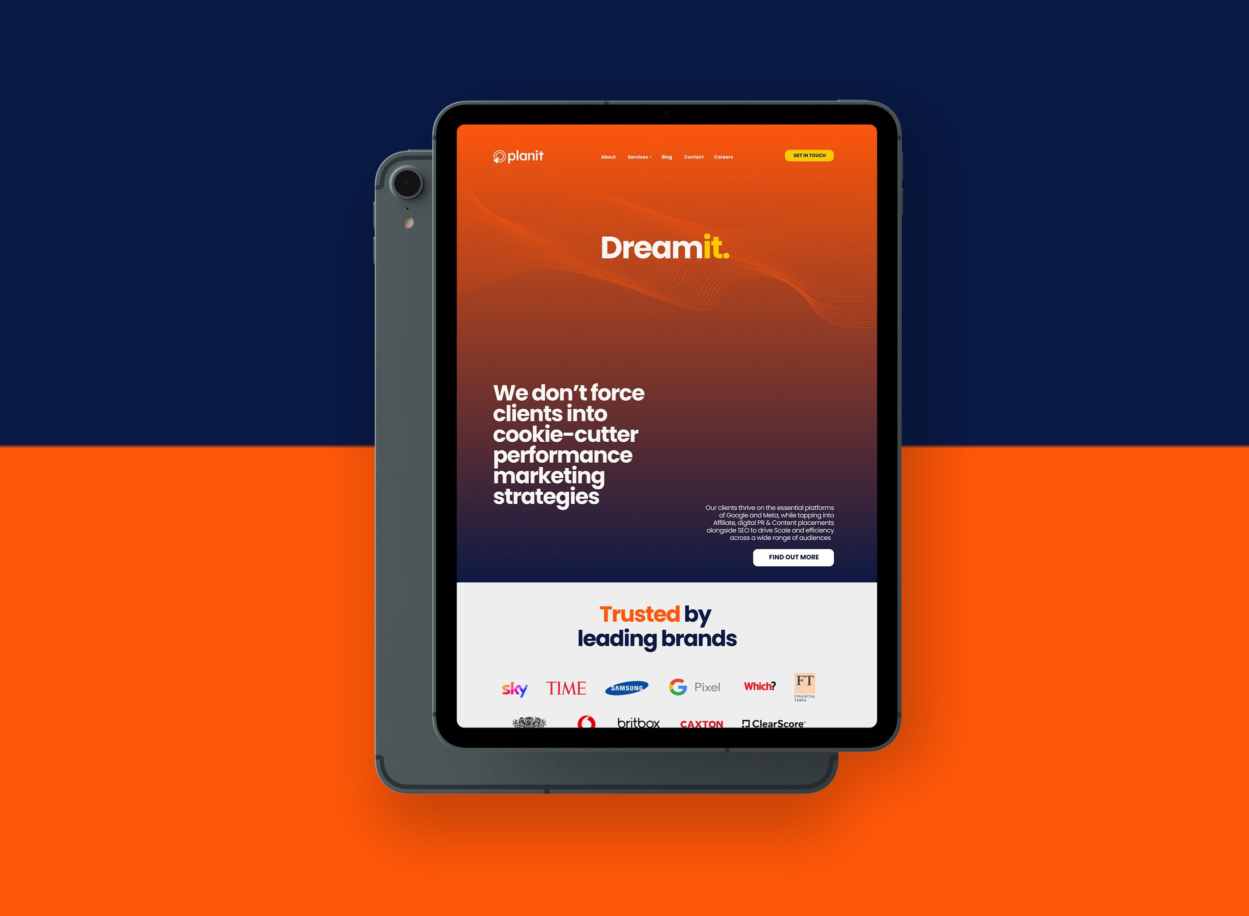 A tablet displaying a website with a gradient orange to dark background, featuring the words 'Dream it' and a section about marketing strategies, with logos of trusted brands at the bottom, set against a background divided into navy blue and bright orange sections.