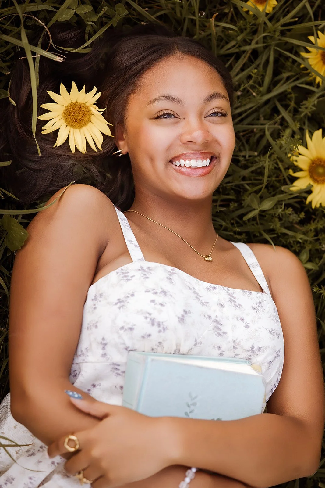 Senior portrait in sunflower field with bible. 