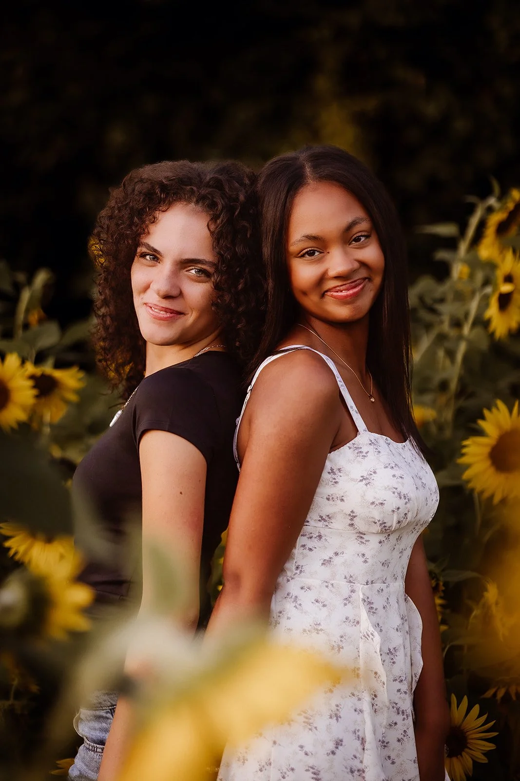 Senior portrait in sunflower field with best friend. 