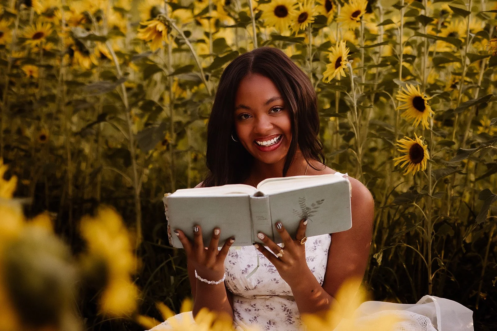 Senior portrait in sunflower field with bible. 