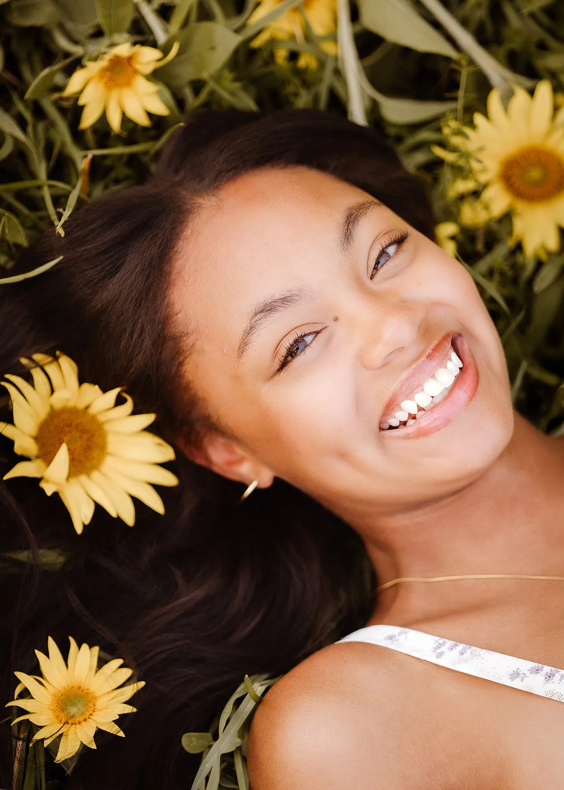 Senior portrait in sunflower field.