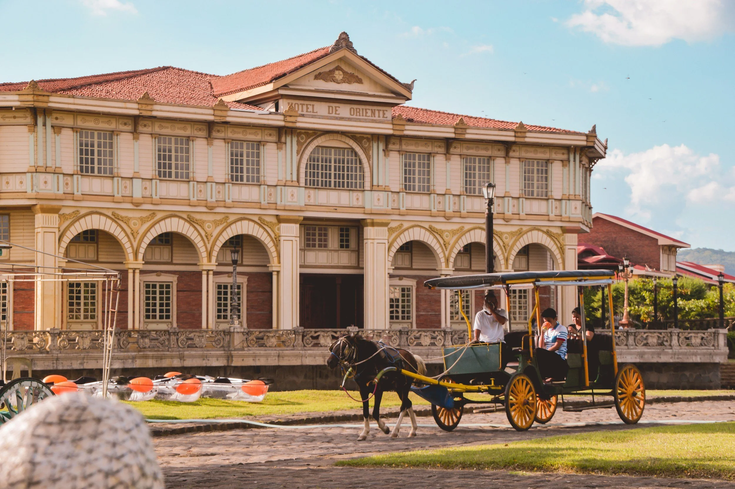 Horse-drawn carriage in front of a historic hotel building with a sign reading "Hotel de Oriente."