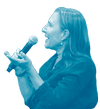 A woman with long hair, wearing earrings and a watch, holding a microphone and speaking.