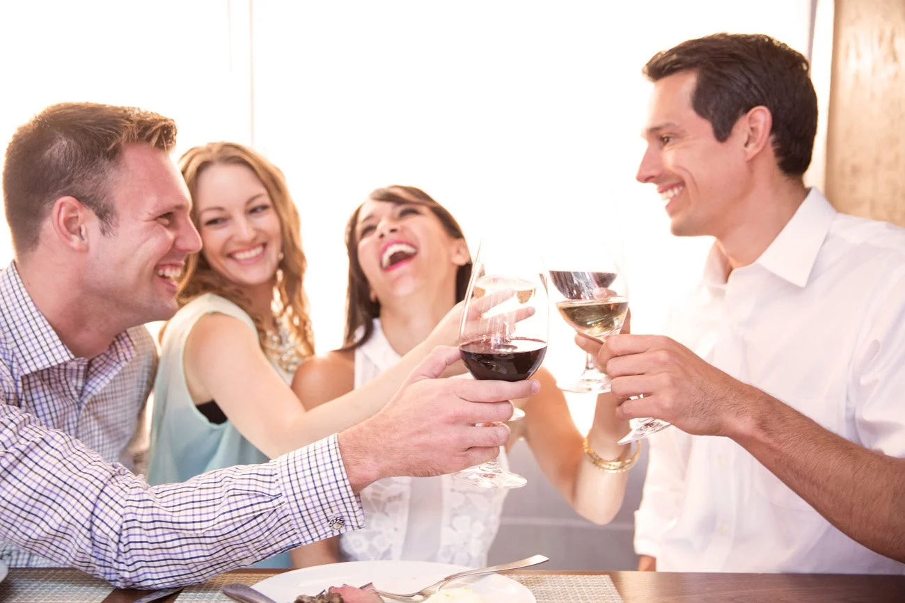 Lifestyle photo of four friends laughing and toasting with wine at a bright restaurant, San Francisco – Marc Olivier Le Blanc Photography