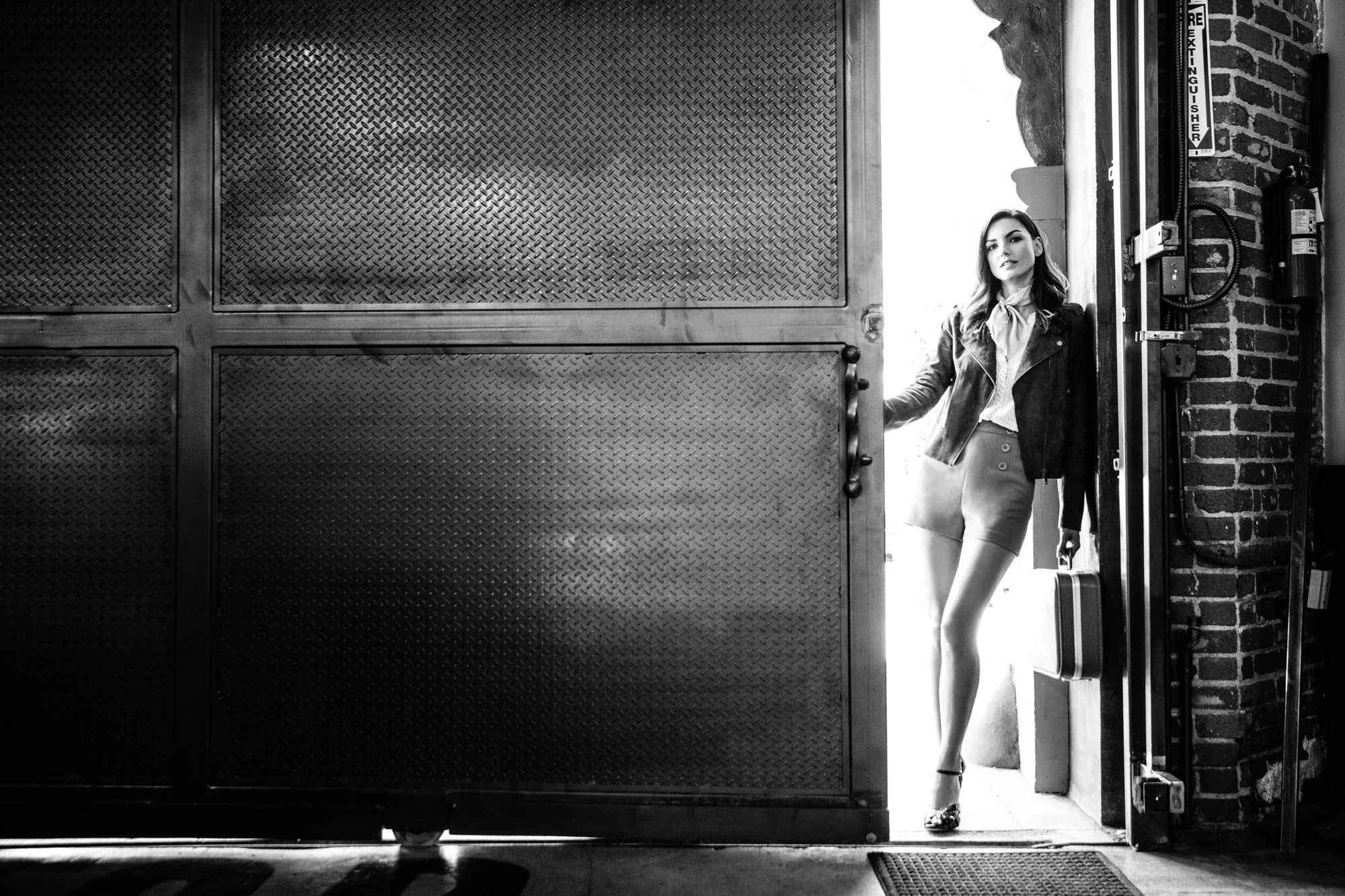 Portrait of model with vintage race car in Los Angeles Chinatown garage, commercial photographer Marc Olivier Le Blanc