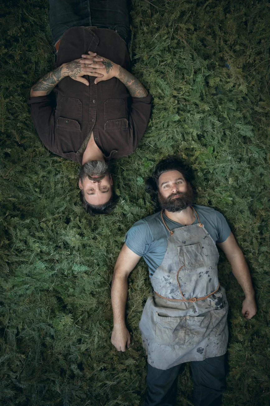 Editorial overhead portrait of two men lying on a lush bed of pine branches, San Francisco – Marc Olivier Le Blanc Photography