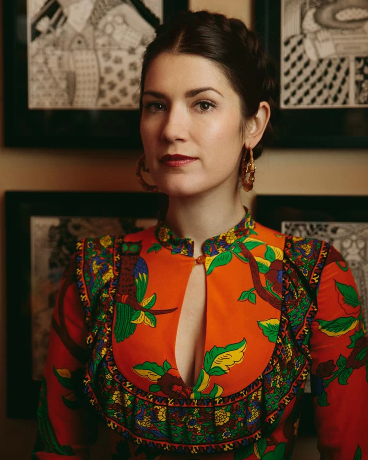 Editorial portrait of a woman in a bold orange floral dress in front of framed artwork, San Francisco – Marc Olivier Le Blanc Photography