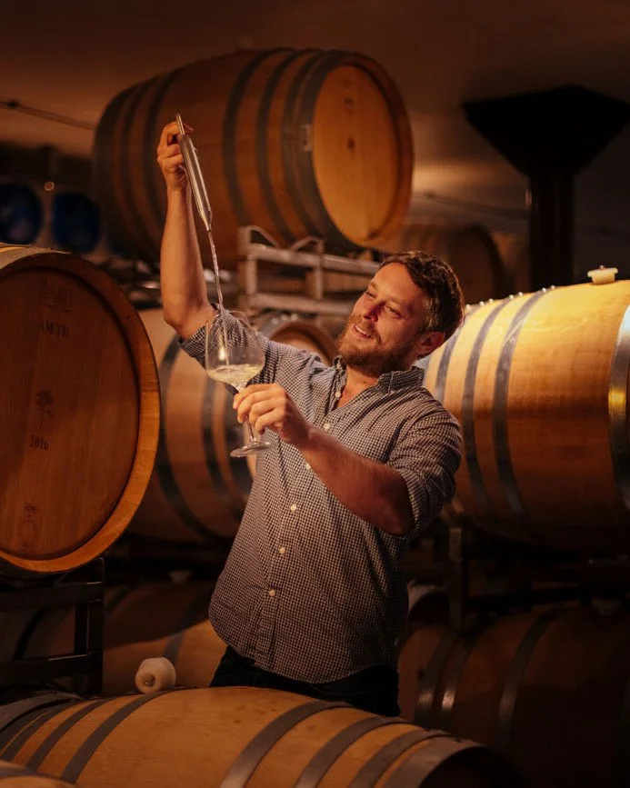 Lifestyle portrait of a winemaker drawing wine from a barrel in a Napa Valley wine cellar – Marc Olivier Le Blanc Photography
