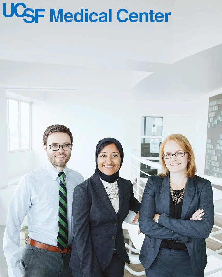 Advertising group portrait of three UCSF Medical Center doctors smiling in a bright hospital corridor, San Francisco – Marc Olivier Le Blanc Photography