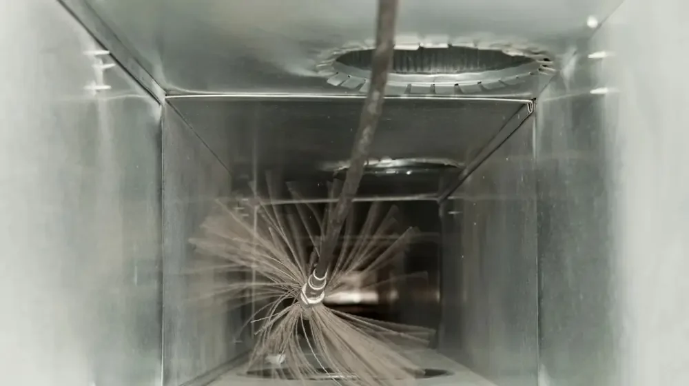 A duct cleaning tool inside of a ventilation system spinning around to remove dirt and debris.