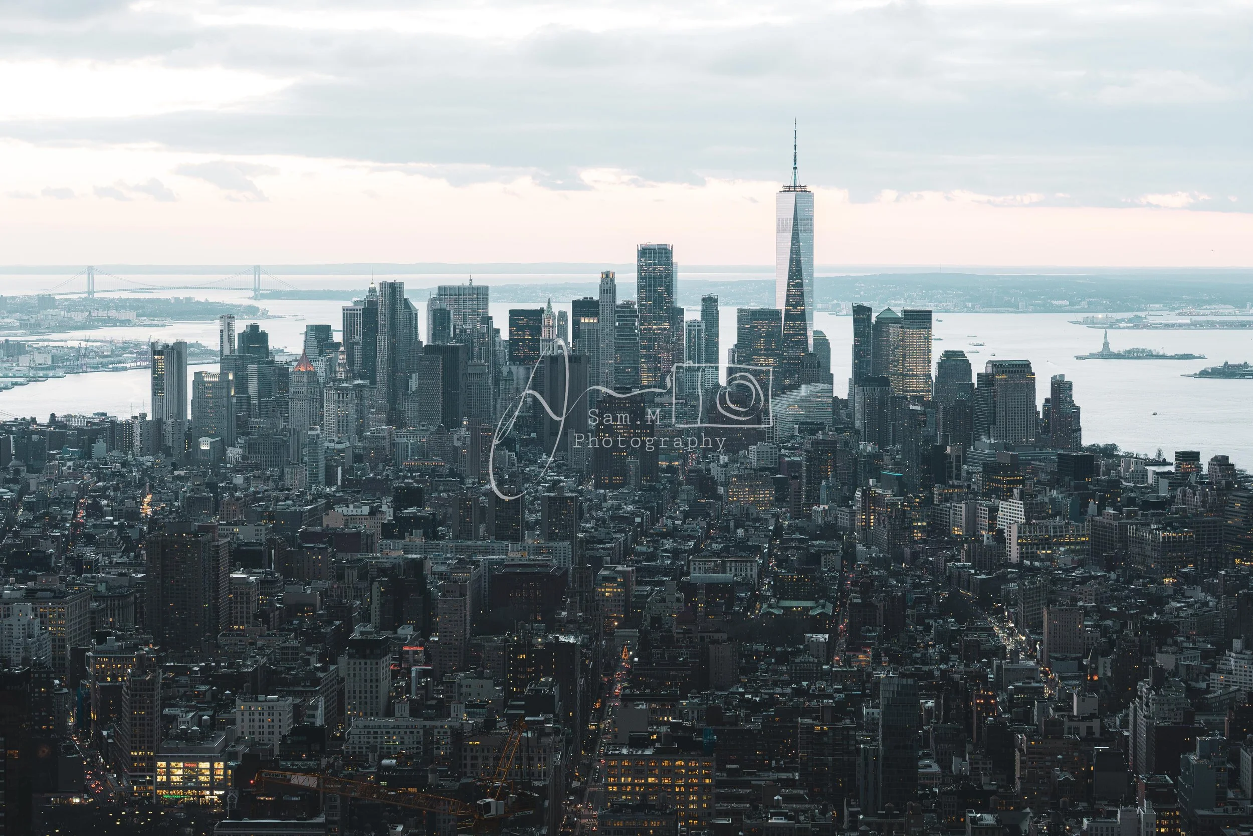 A view of New York City skyline with One World Trade Center, skyscrapers, and waterfront during daytime.