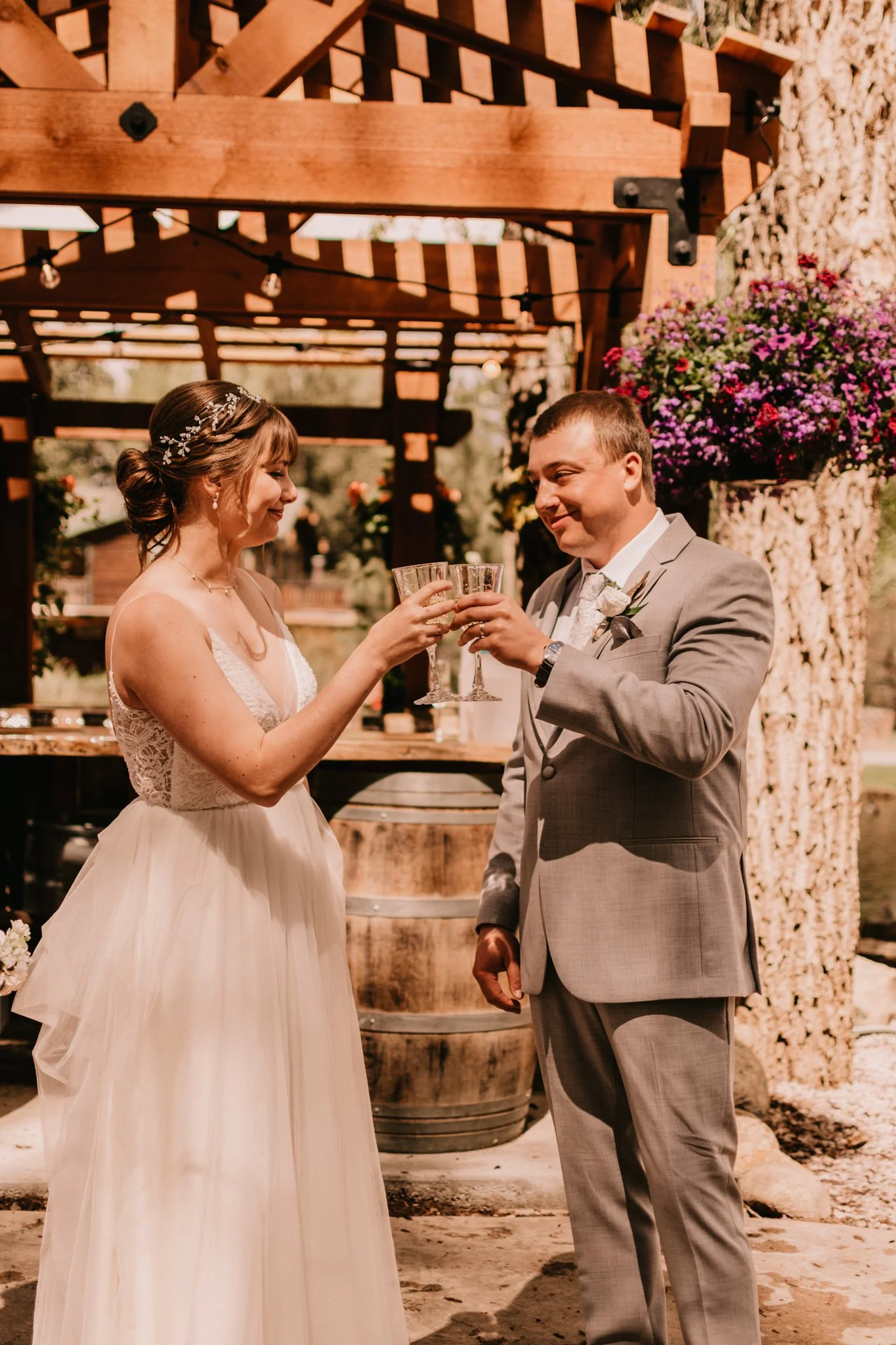 Bride and groom toasting with champagne glasses during their wedding ceremony outdoors.