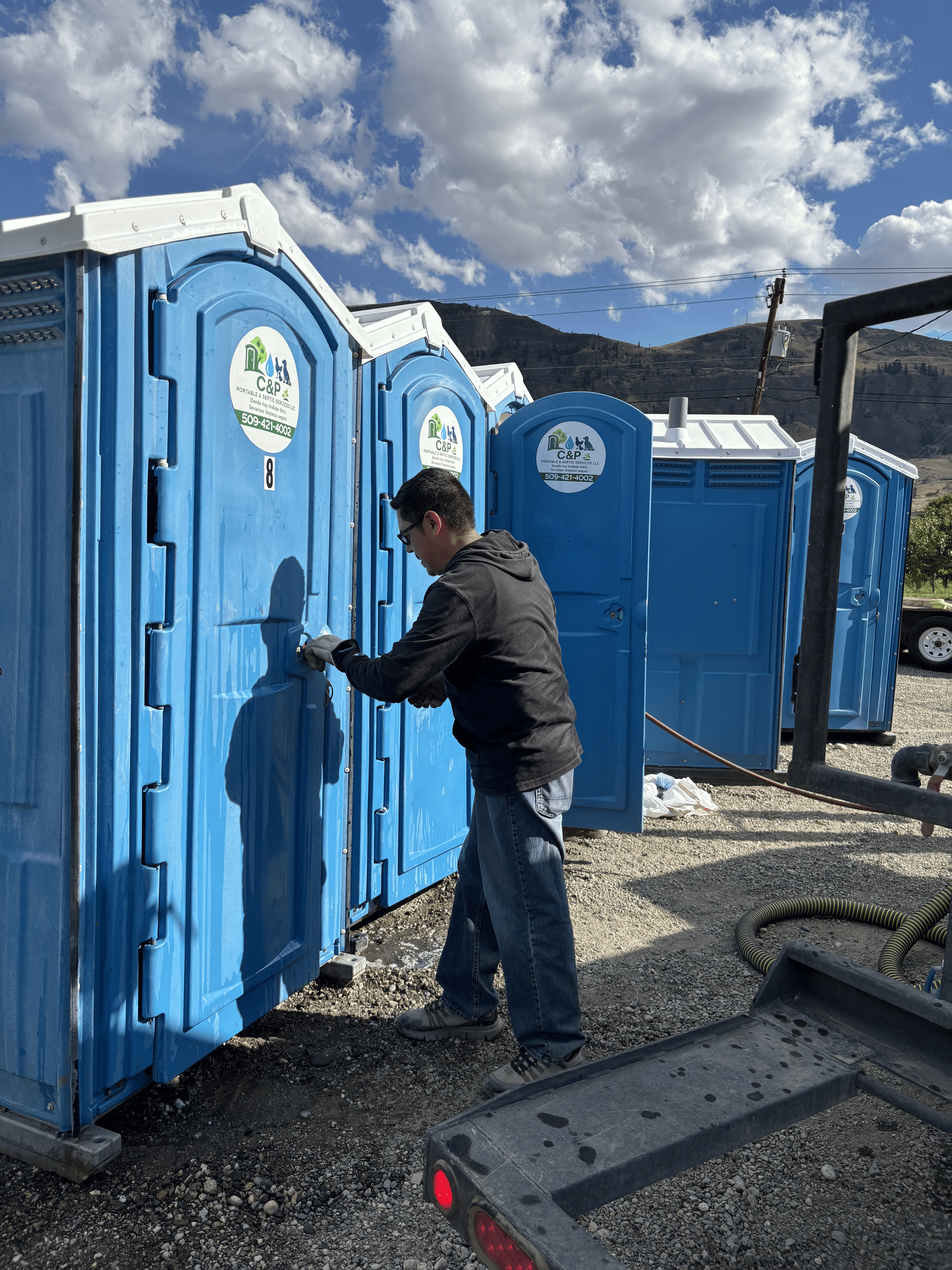 Man finishes cleaning portable restroom.