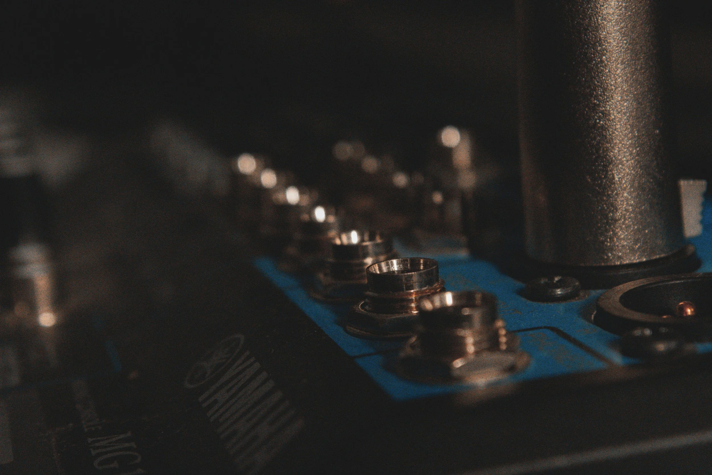 Close-up of an engine with visible metallic components and bolts, with a textured metallic surface on the right side of the image.